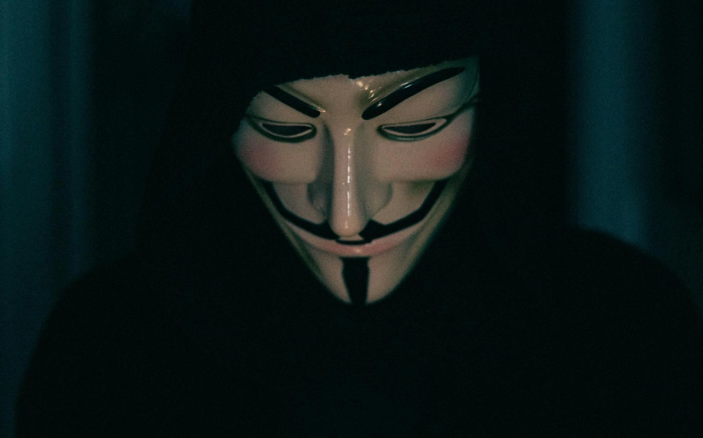 a person wearing a mask using a cell phone by Erik Mclean courtesy of Unsplash.