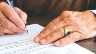 Hands signing paperwork