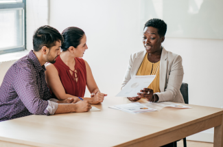 Financial advisor with clients discussing paperwork