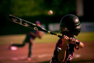 selective focus photography of person holding baseball bat by Eduardo Balderas courtesy of Unsplash.