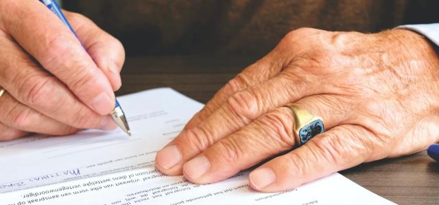 Hands signing paperwork