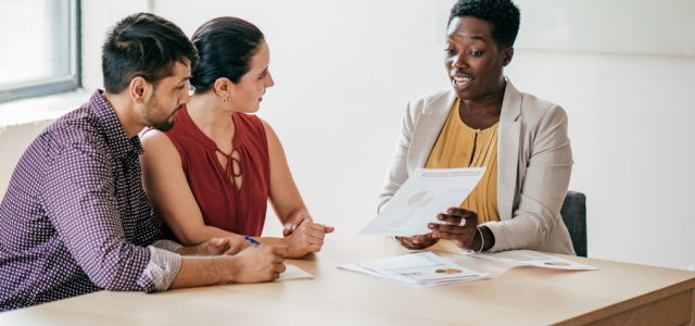 Financial advisor with clients discussing paperwork